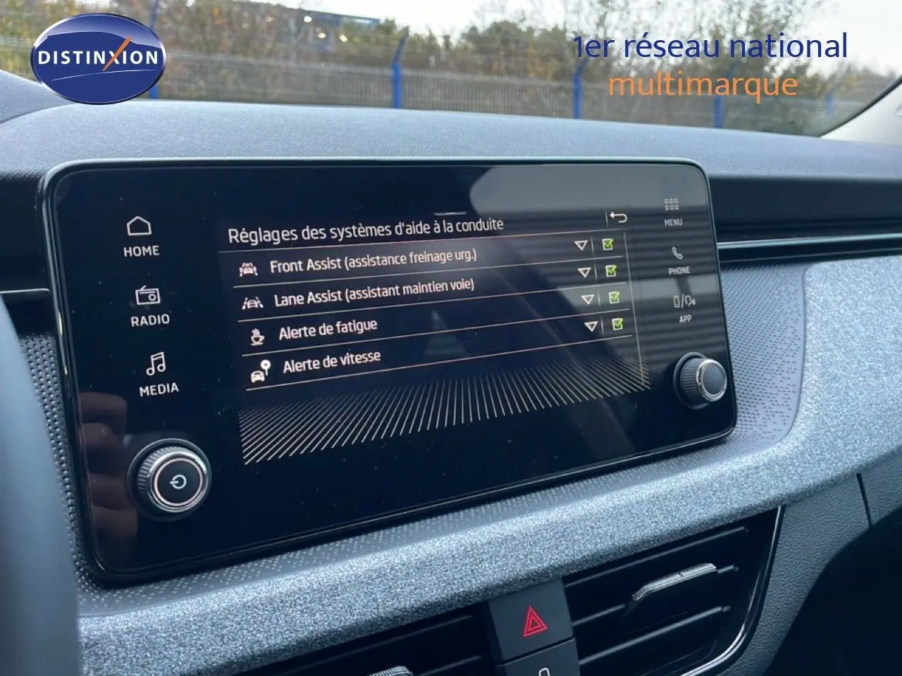 Vue rapprochée de l’écran tactile intérieur du Skoda Kamiq 2025 gris graphite, affichant les aides à la conduite.