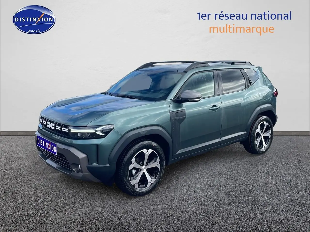 Dacia Duster 1.2 mild hybrid vert cèdre en 3/4 avant droit, avec jantes alliage et barres de toit noires.
