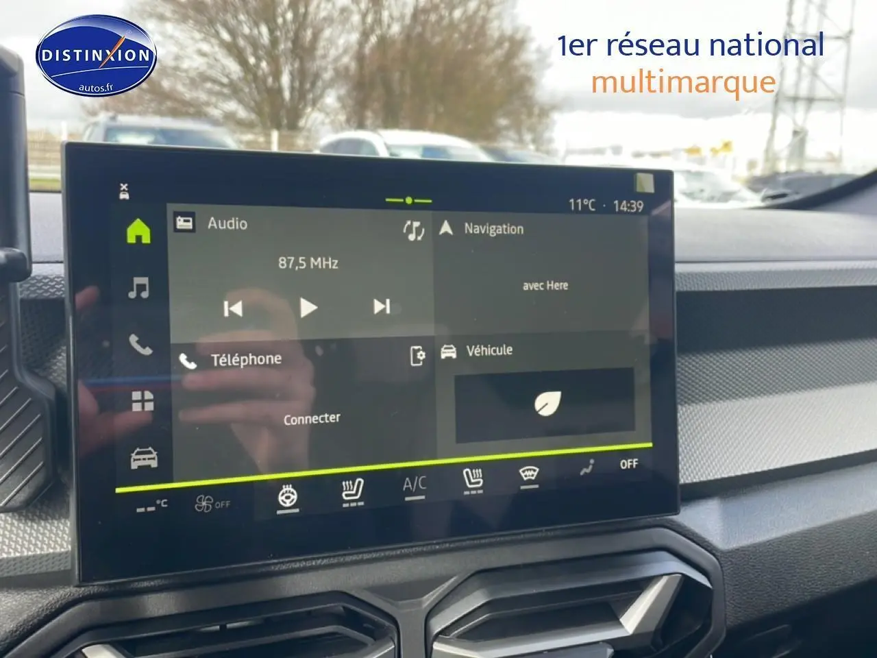 Écran tactile central du tableau de bord du Dacia Duster 2026 avec commandes audio et navigation visibles.