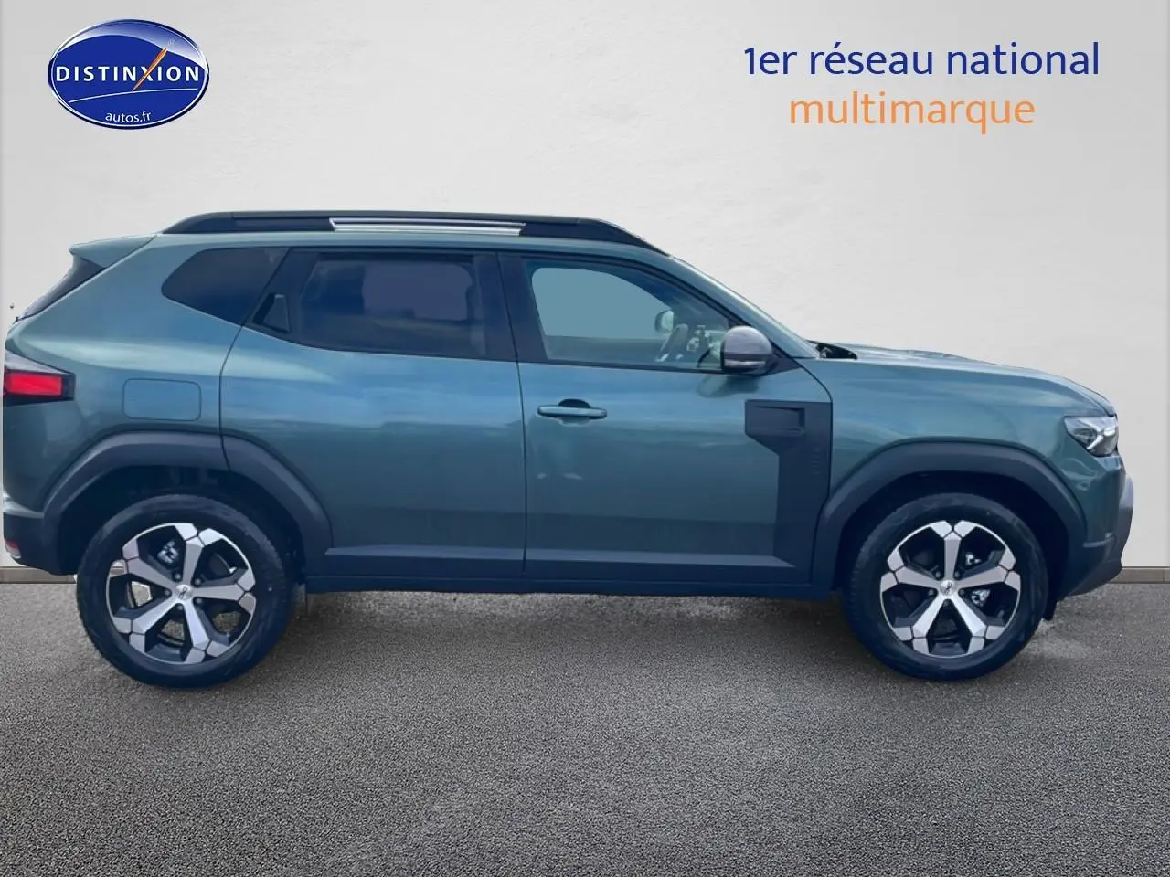 Profil droit du Dacia Duster 2026 vert cèdre avec jantes alu et barres de toit visibles sur fond neutre.