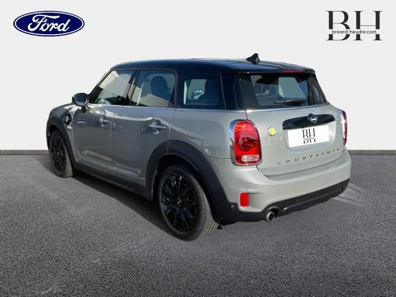 Vue 3/4 arrière droite d'une MINI Countryman Moonwalk Grey avec toit noir panoramique et jantes noires.