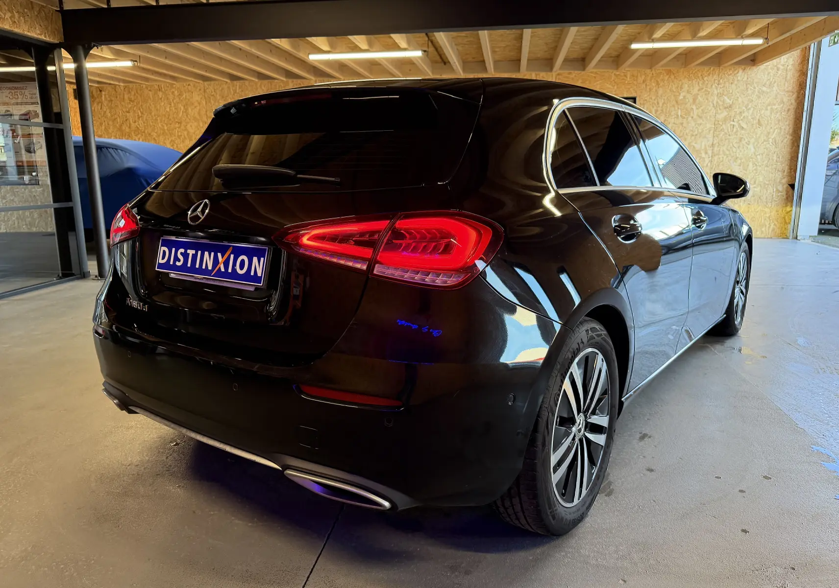 Vue 3/4 arrière droite d'une Mercedes Classe A noire avec feux LED et jantes alliage dans un garage.