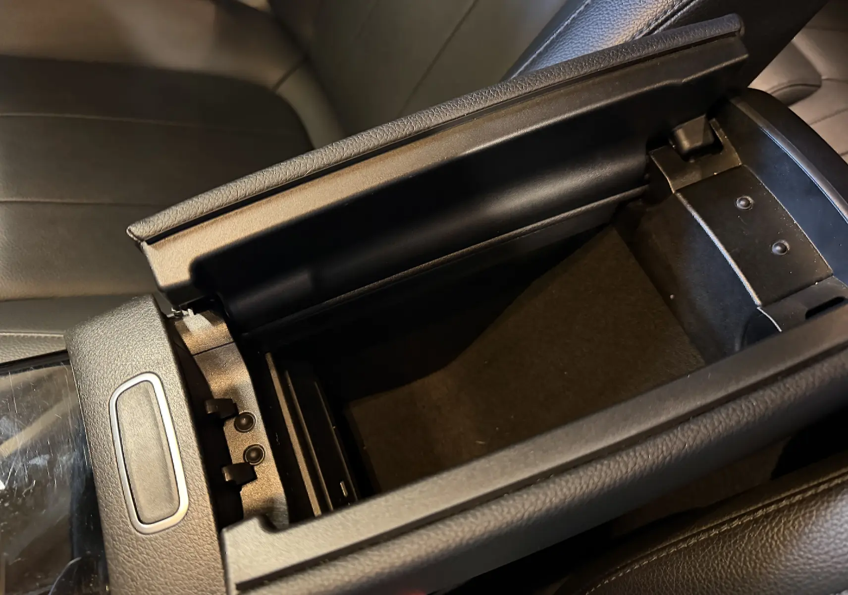 Vue rapprochée de l'accoudoir central avant noir ouvert de la Mercedes Classe A 2022, intérieur cuir noir.