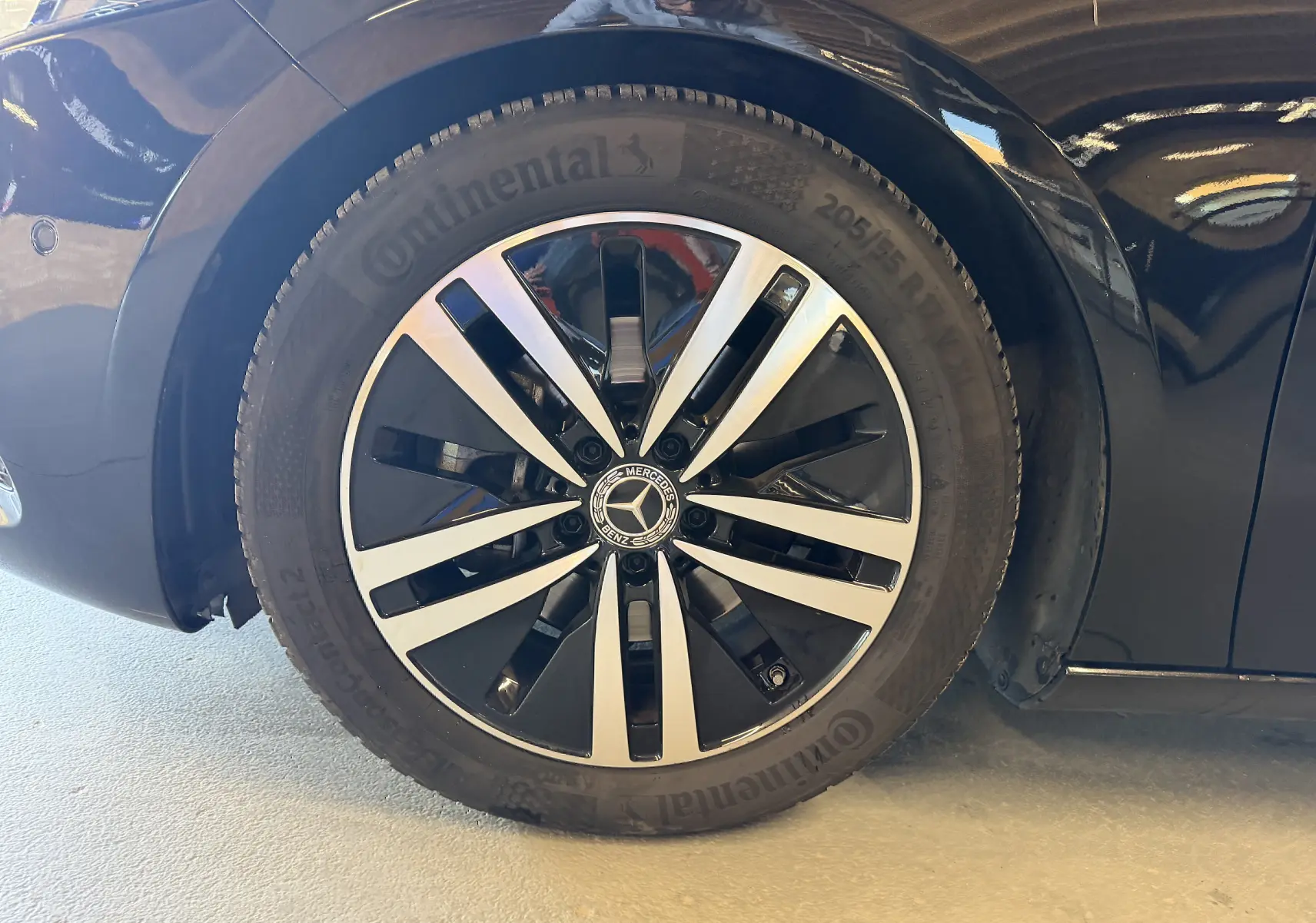 Gros plan sur la jante alu noire et argentée d'une Mercedes Classe A noire, côté avant droit.