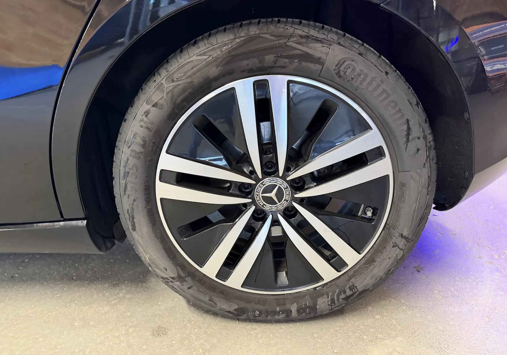 Gros plan sur la jante alu bicolore noire et argent d’une Mercedes Classe A noire, avec pneu Continental visible.