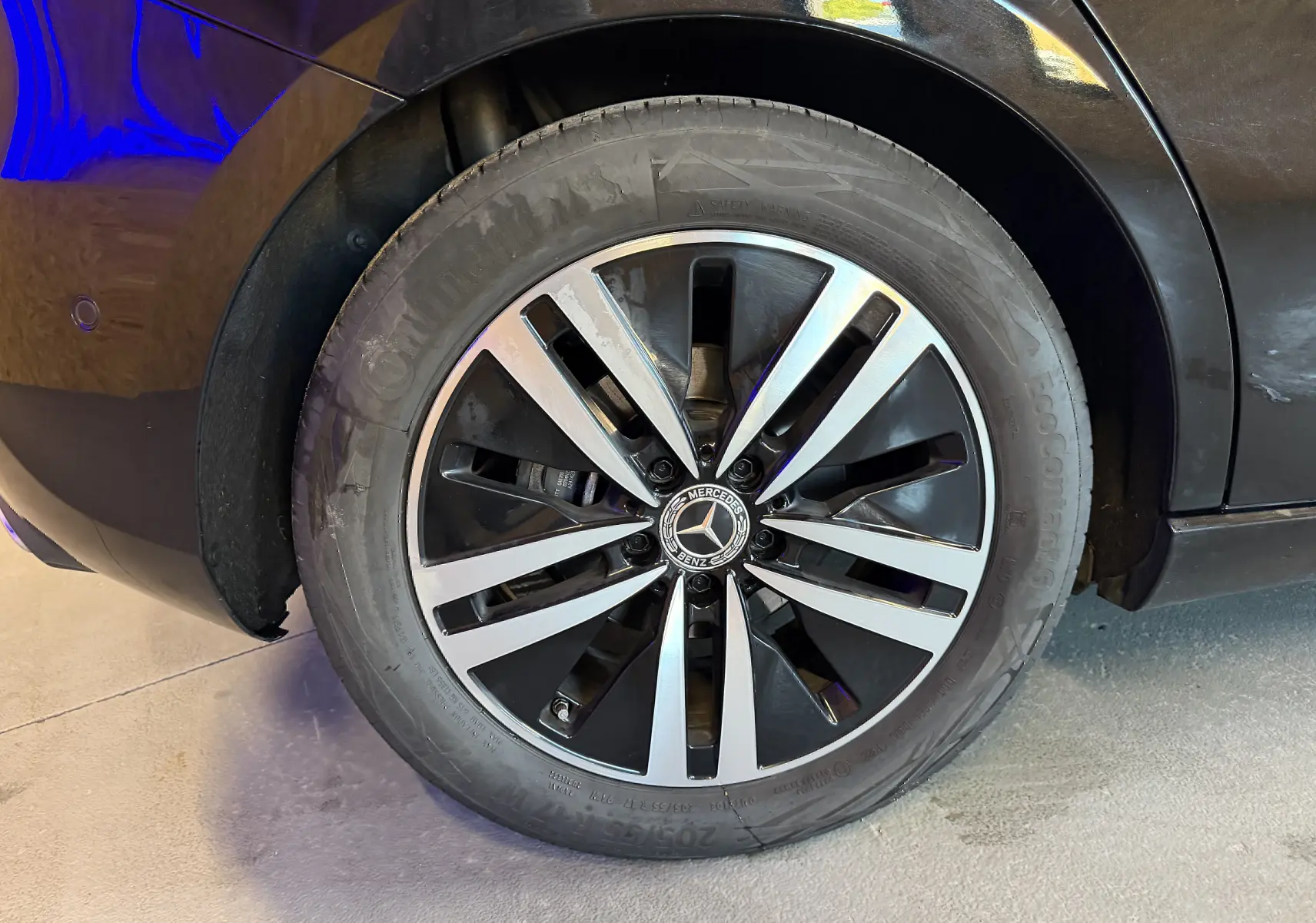 Gros plan sur la jante alu noire et argentée d'une Mercedes Classe A noire, vue côté arrière droit.