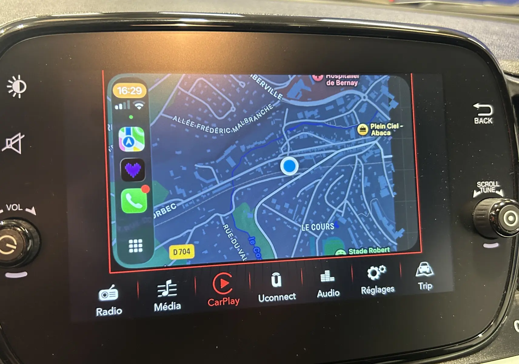 Écran tactile central de la Fiat 500 hybride affichant la navigation CarPlay avec carte et options multimédia visibles.