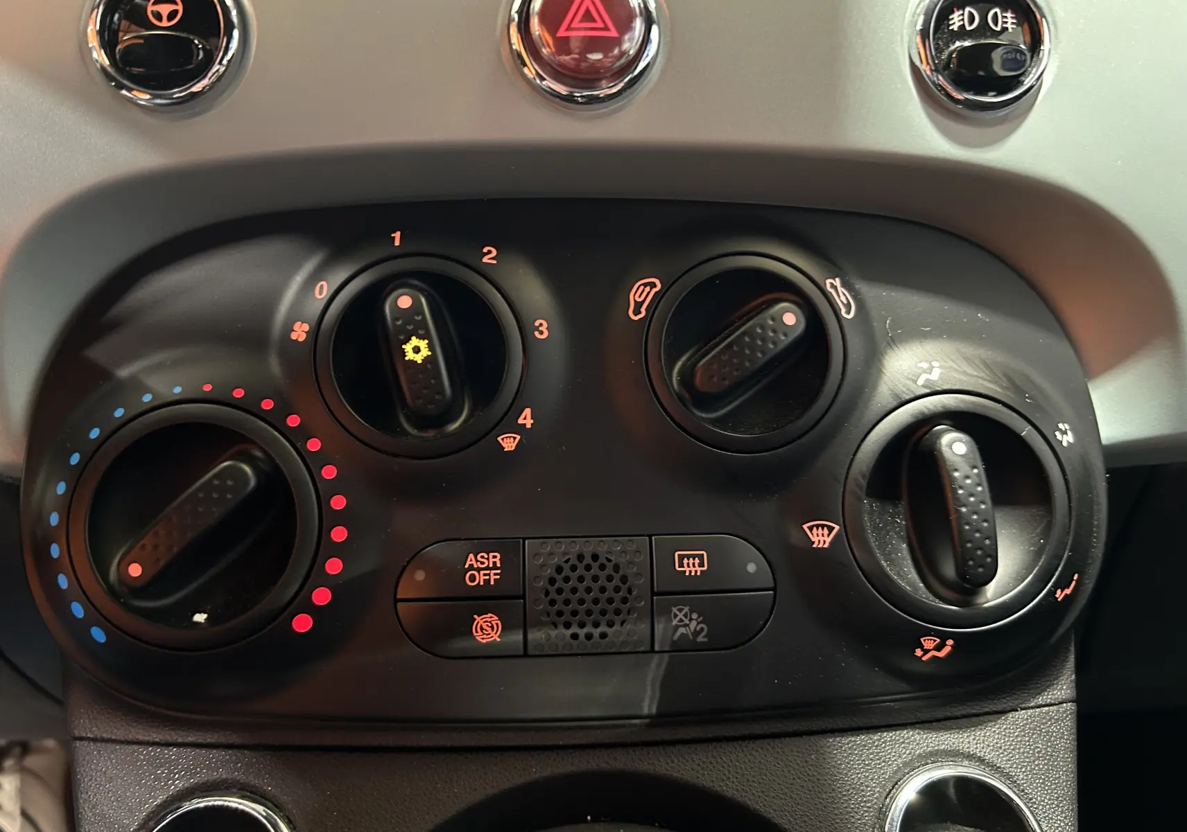 Gros plan sur les commandes de climatisation et boutons du tableau de bord de la FIAT 500 70 Hybride Pack Confort & Style 2023.