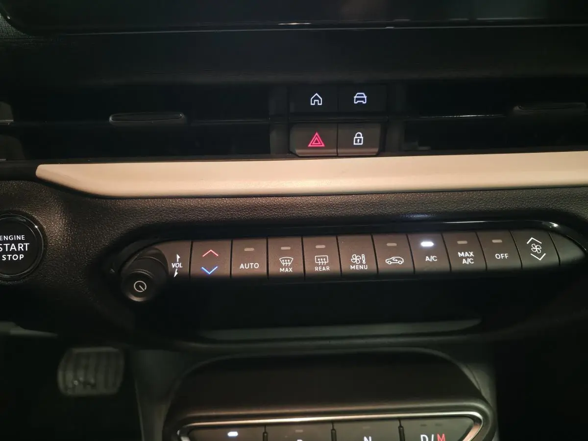 Vue rapprochée de la console centrale de la FIAT 600 rouge 2024, montrant les commandes de climatisation et démarrage.