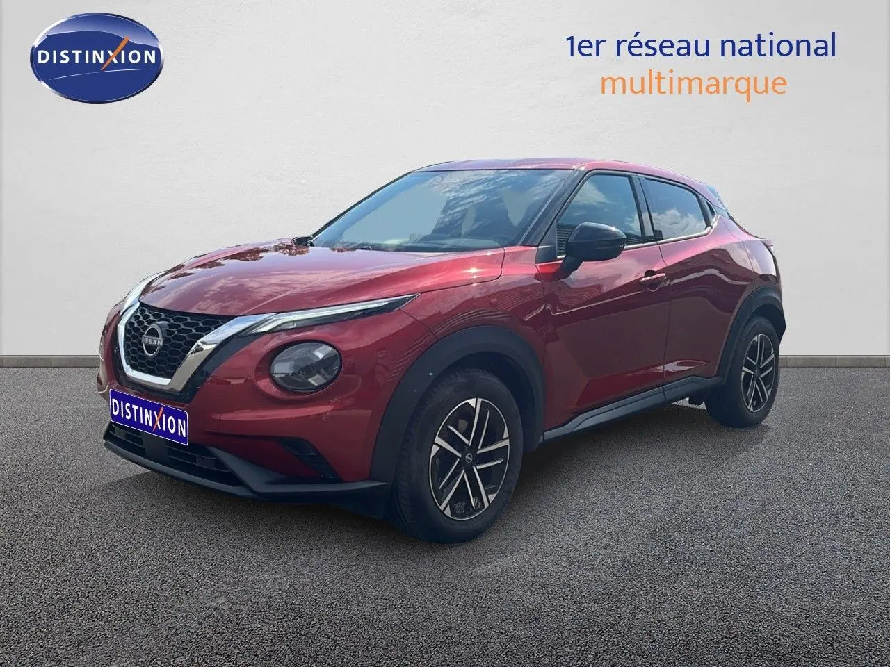 Nissan Juke rouge Fuji Metal en 3/4 avant droit, avec jantes alliage et calandre chromée distinctive.