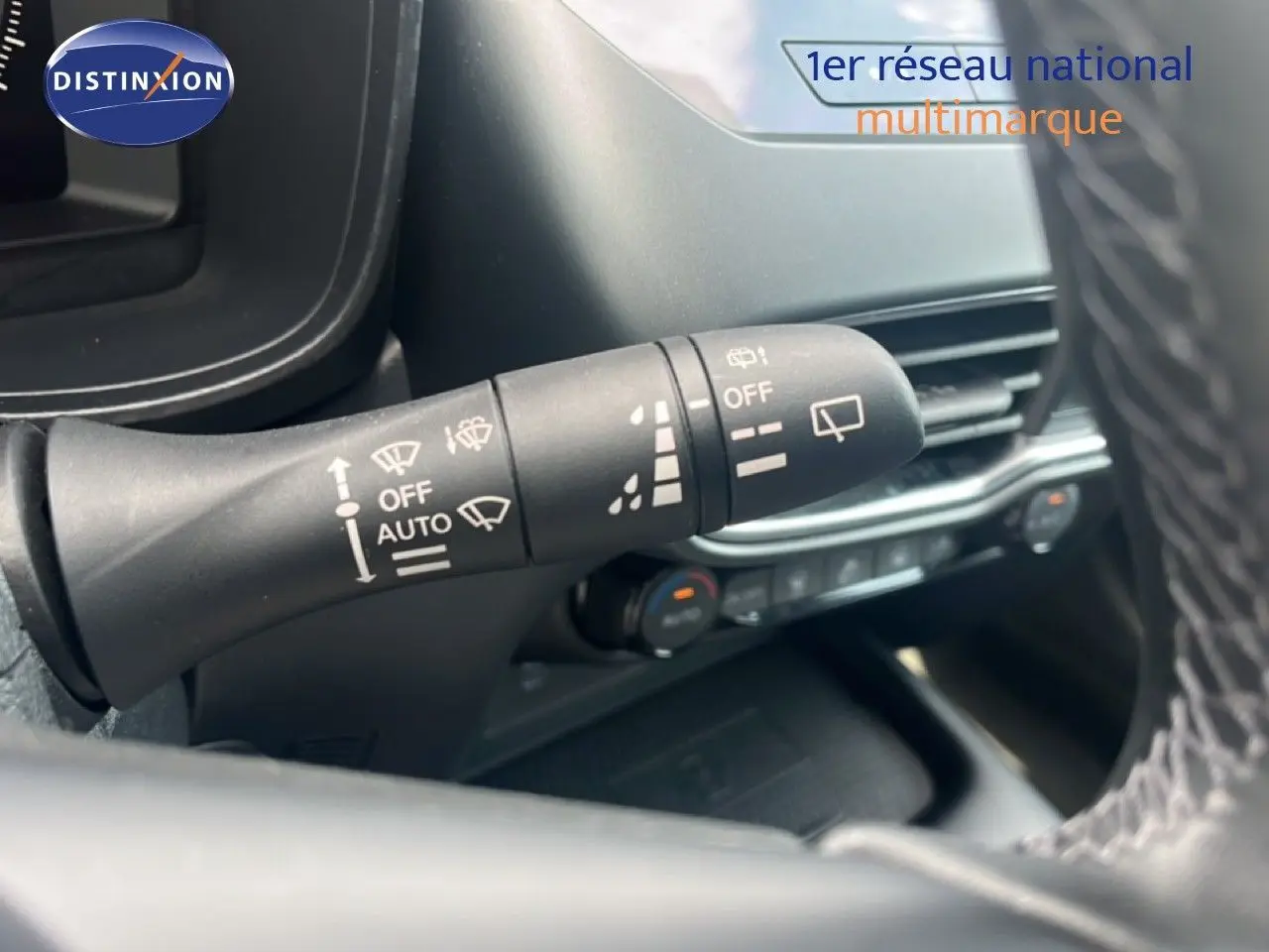 Gros plan sur la commande des essuie-glaces du Nissan Juke rouge Fuji Metal 2024, intérieur noir avec volant cuir.
