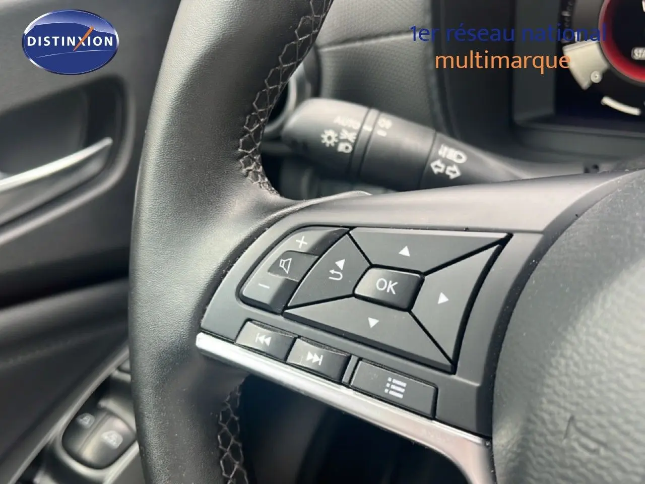Gros plan sur les commandes au volant d’un Nissan Juke 2024, finition N-Connecta, intérieur noir.