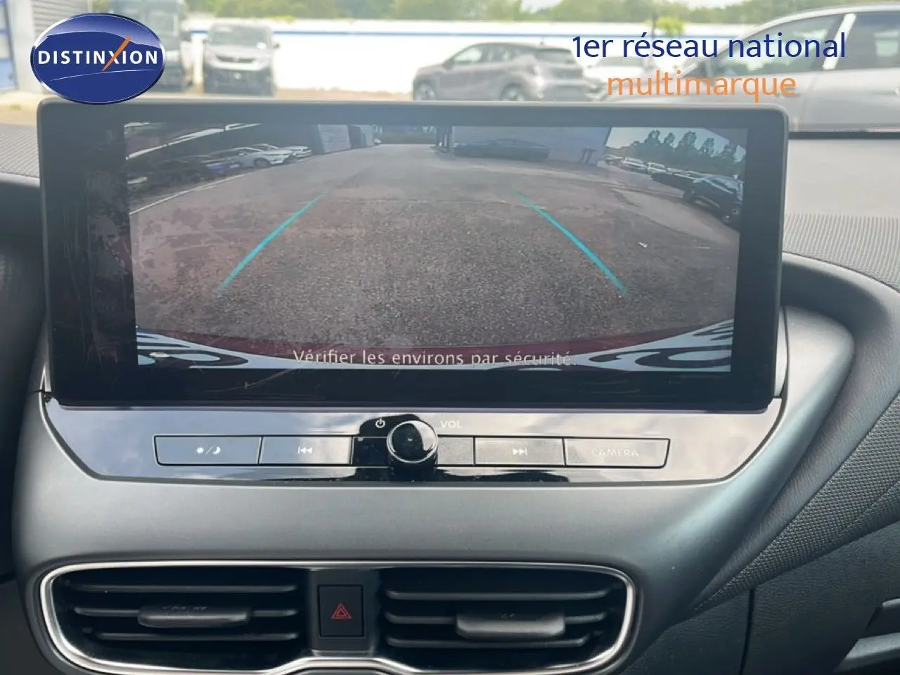 Écran central affichant la caméra de recul du Nissan Juke rouge Fuji Metal, vue intérieure du tableau de bord.