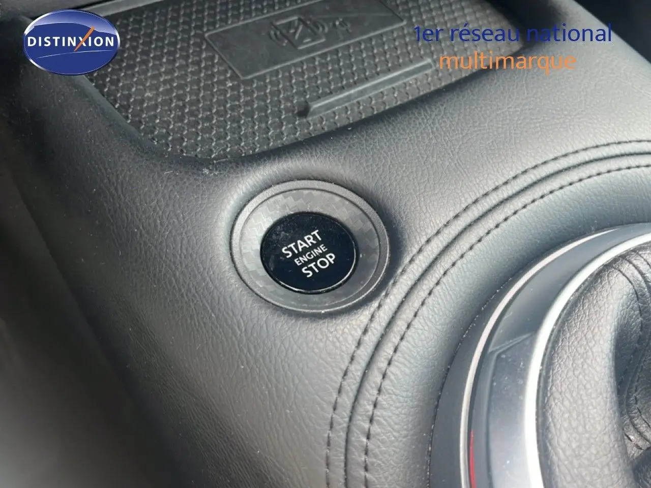 Gros plan sur le levier de vitesses en cuir noir de la Nissan Juke rouge Fuji Metal, version 2024 DIG-T 114CH N-Connecta.