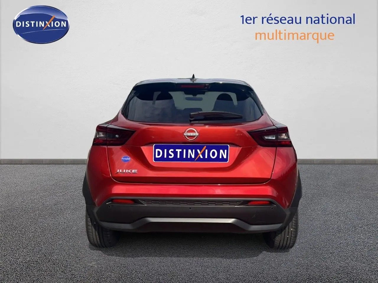 Vue arrière d'un Nissan Juke rouge Fuji Metal 2024, soulignant ses feux arrière modernes et son design compact.