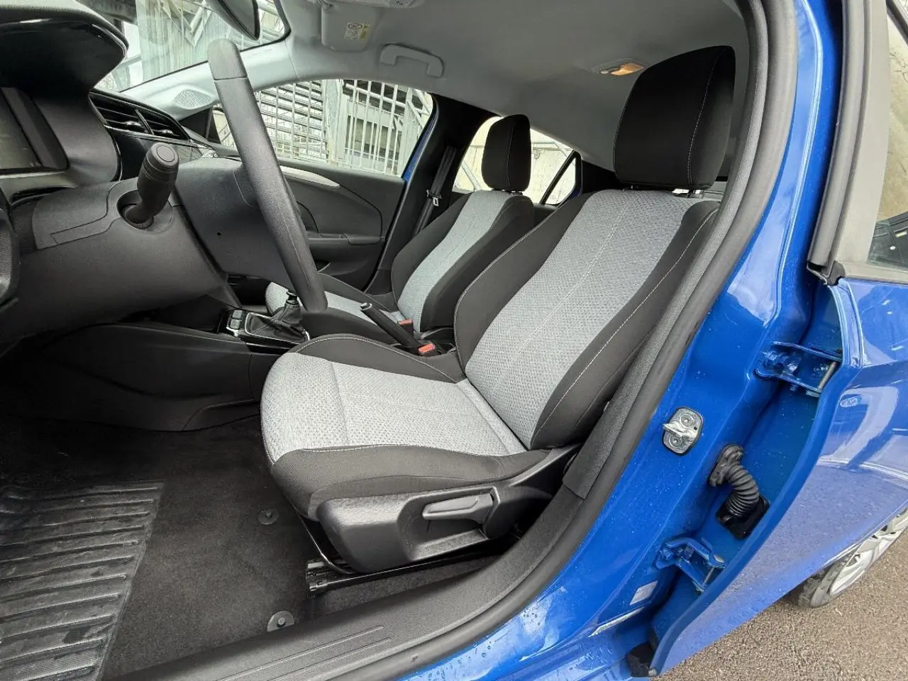 Intérieur côté conducteur de l’Opel Corsa 2025 bleu voltaik, montrant les sièges avant et la boîte manuelle.