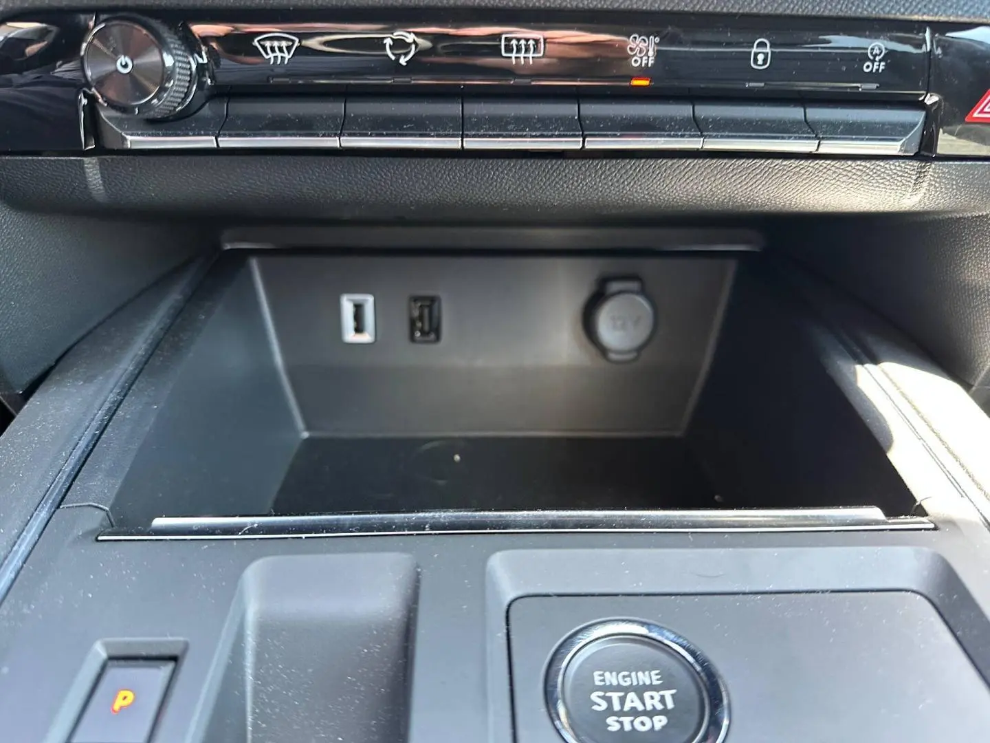 Gros plan intérieur sur la console centrale noire du Citroën C5 Aircross avec bouton start/stop et prises USB visibles.
