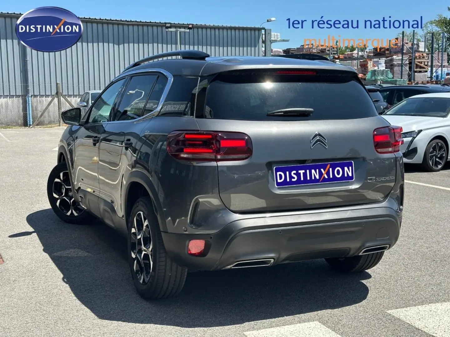 Vue 3/4 arrière droite d'un Citroën C5 Aircross gris Platinium avec feux LED et jantes alu noires.