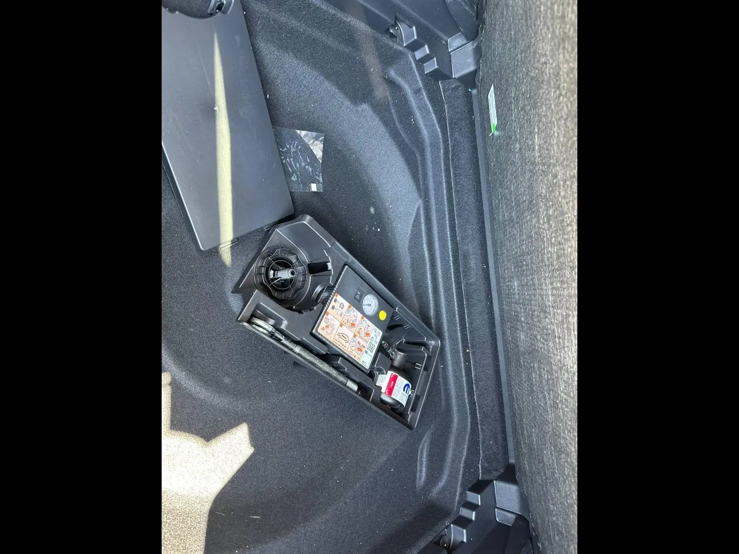 Vue du coffre du Citroën C5 Aircross 2025 gris Platinium, montrant le compartiment de rangement avec kit de réparation pneus.