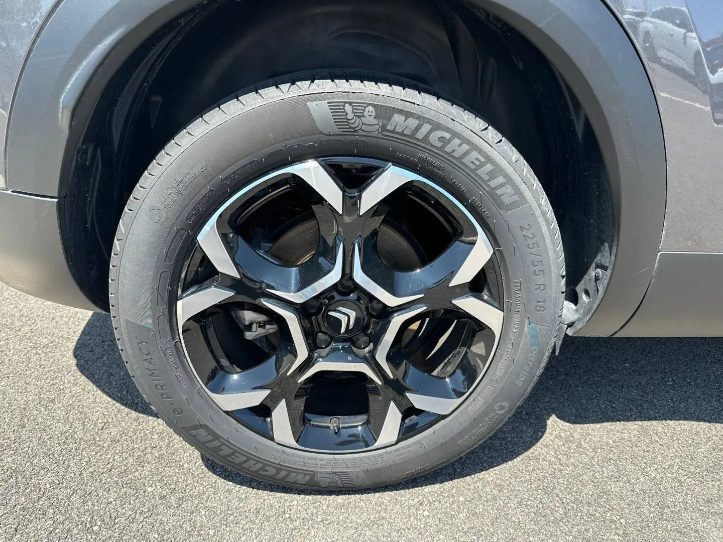 Gros plan sur la jante alu noire et argentée Michelin du côté arrière droit d'un Citroën C5 Aircross gris Platinium.