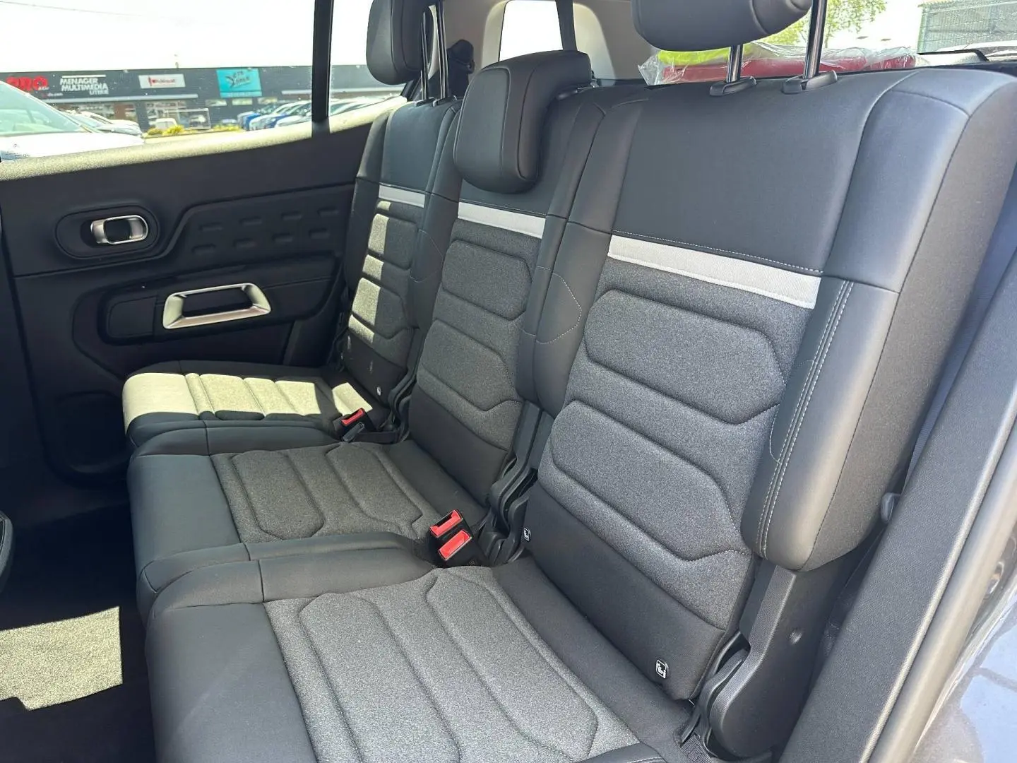Vue latérale droite des trois sièges individuels gris foncé de la deuxième rangée du Citroën C5 Aircross 2025.