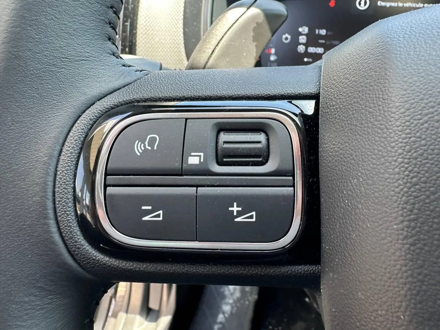 Gros plan sur les commandes vocales et volume au volant cuir noir du Citroën C5 Aircross 2025.