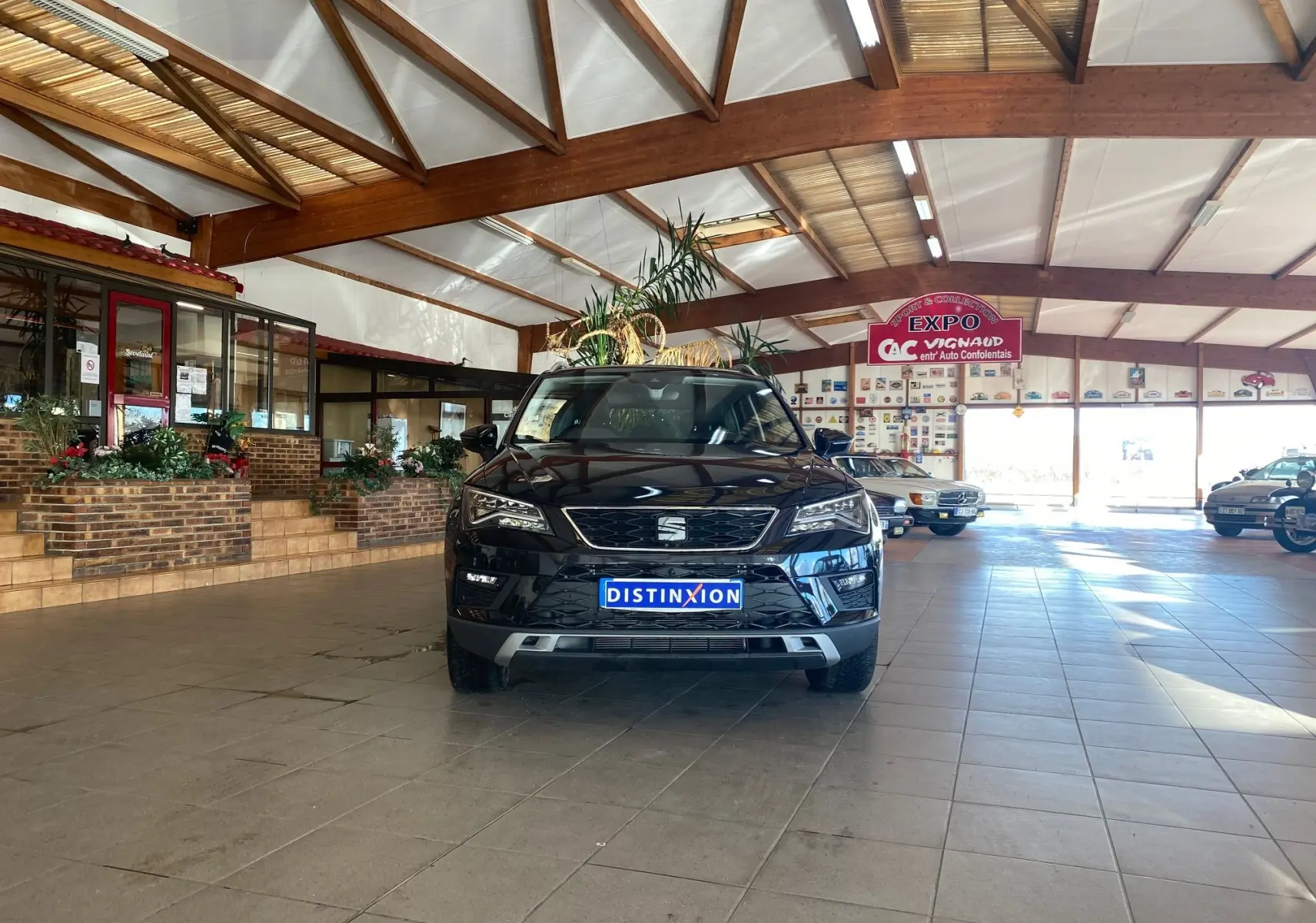 Vue frontale d'un SEAT Ateca Urban noir 2019 dans un showroom lumineux avec plaques d'immatriculation Distinxion.