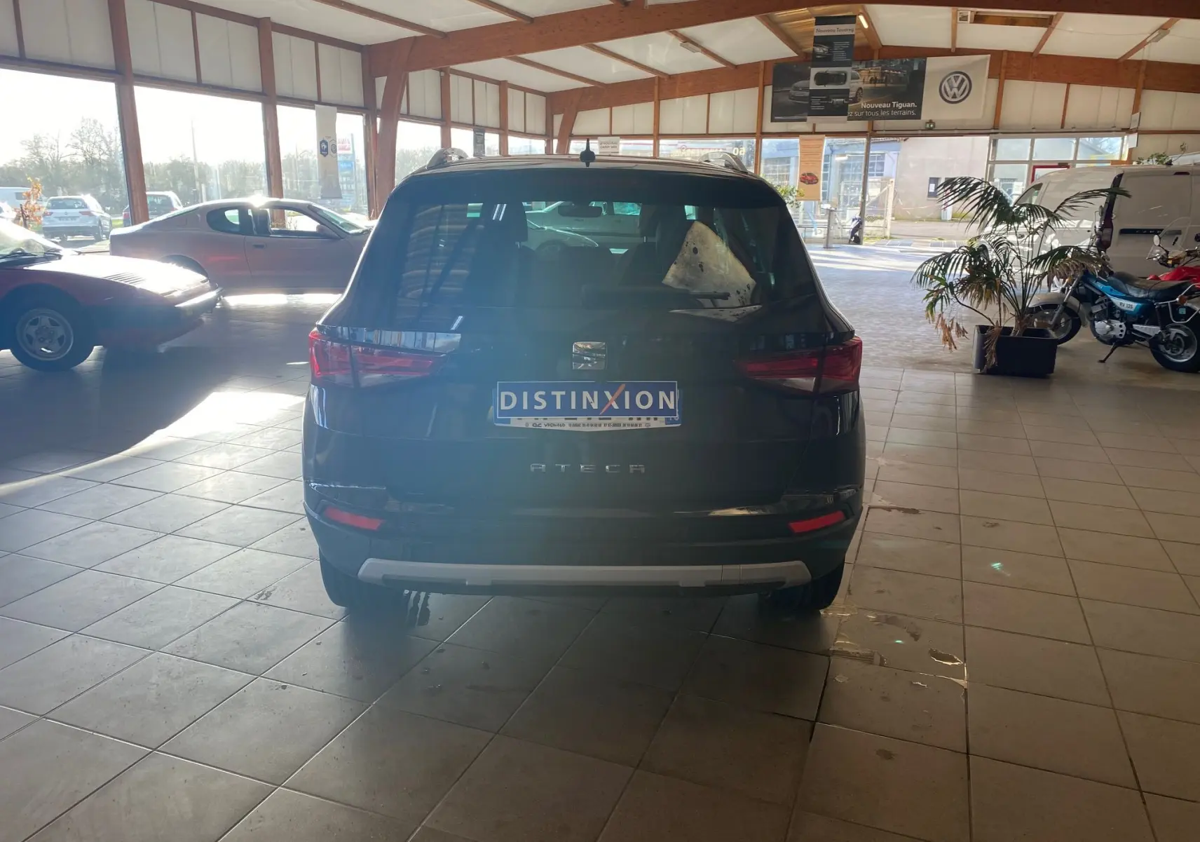 Vue arrière d'un SEAT Ateca noir 2019 dans un showroom, avec plaque d'immatriculation Distinxion visible.