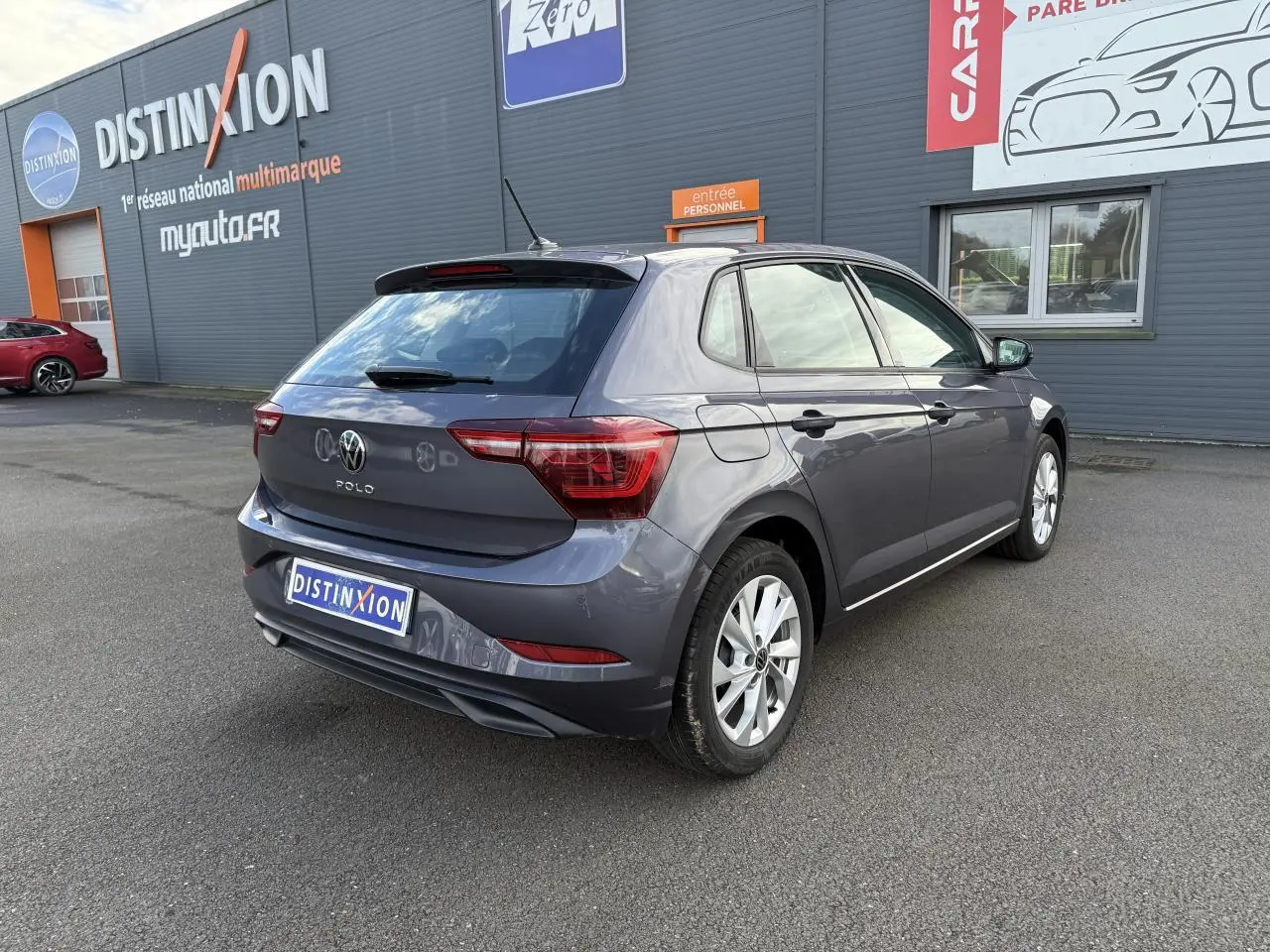 Volkswagen Polo 1.0 TSI gris cendre vue 3/4 arrière droit, avec jantes alliage et feux arrière LED visibles.