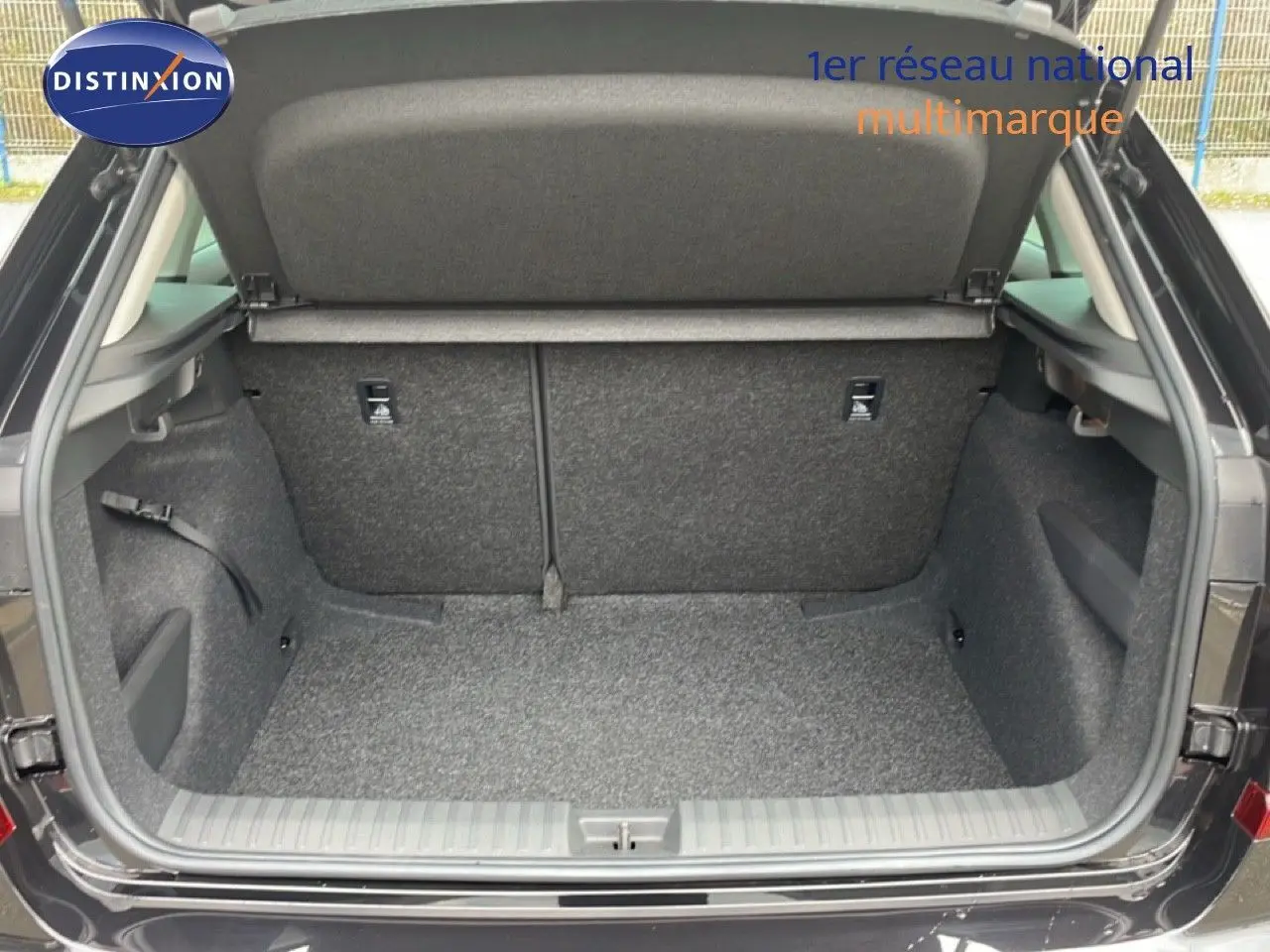 Coffre ouvert vu de l'arrière d'un Skoda Kamiq noir magique métal, montrant un espace de chargement propre et vide.