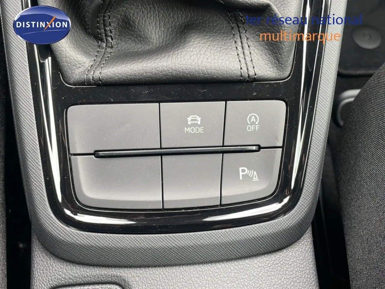 Gros plan sur les boutons de commande de mode de conduite et assistance au stationnement dans une Skoda Kamiq 2025 noir magique métal.