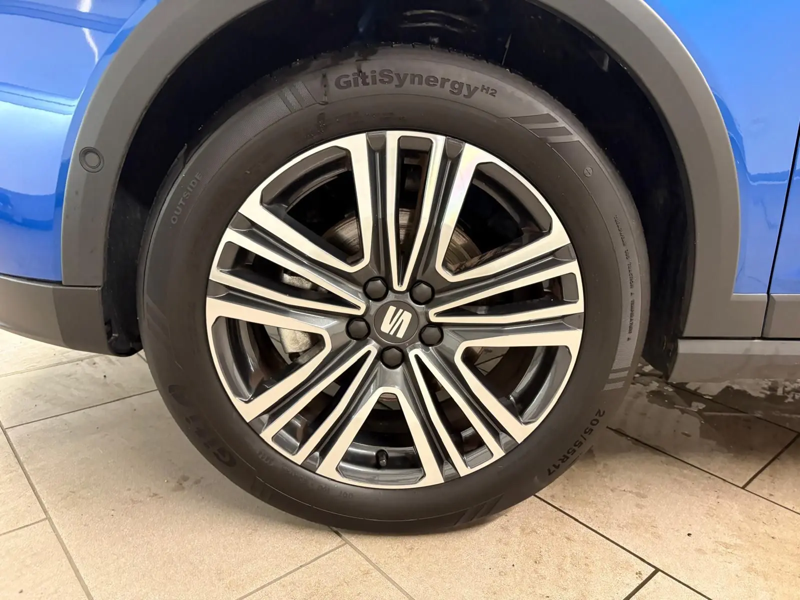 Gros plan sur la roue avant droite du SEAT Arona Bleu Saphir avec jante alliage et partie de la carrosserie visible.