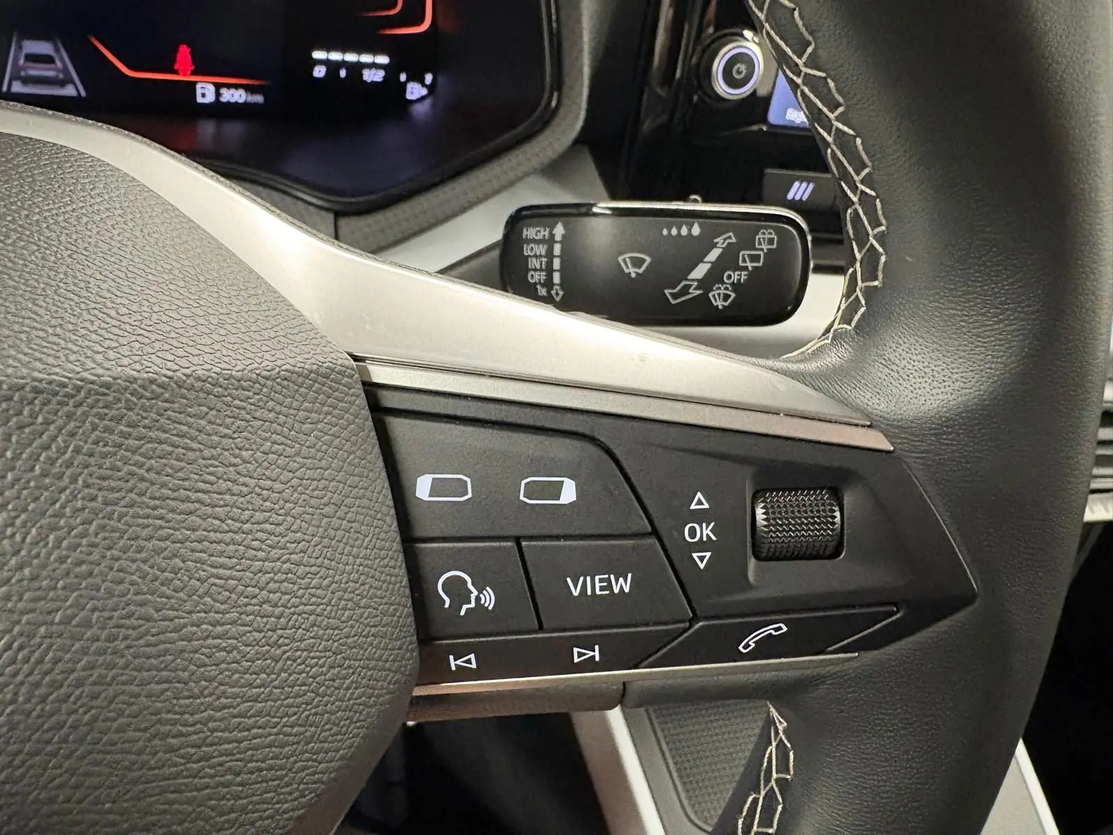 Gros plan sur les commandes au volant du SEAT Arona 2025, mettant en valeur les boutons multifonctions et la molette de réglage.