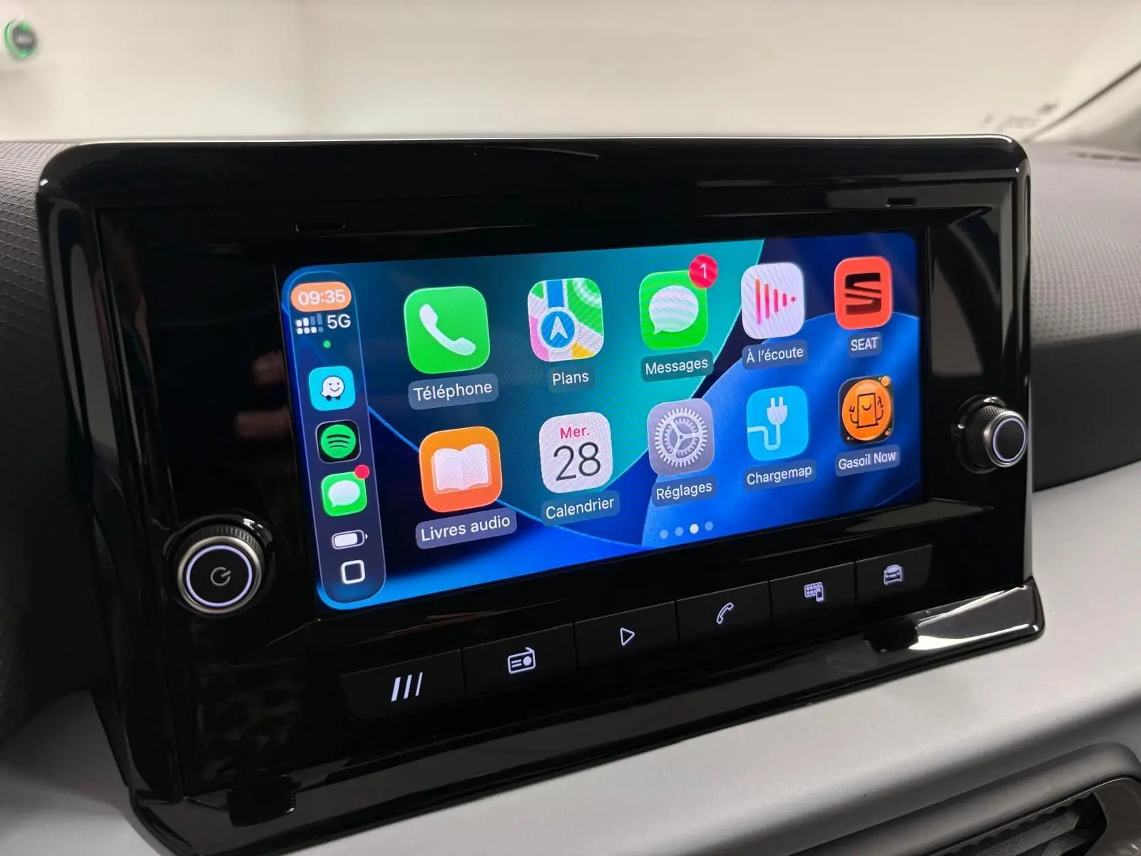 Écran tactile central du SEAT Arona 2025 affichant les applications connectées, entouré de commandes noires brillantes.