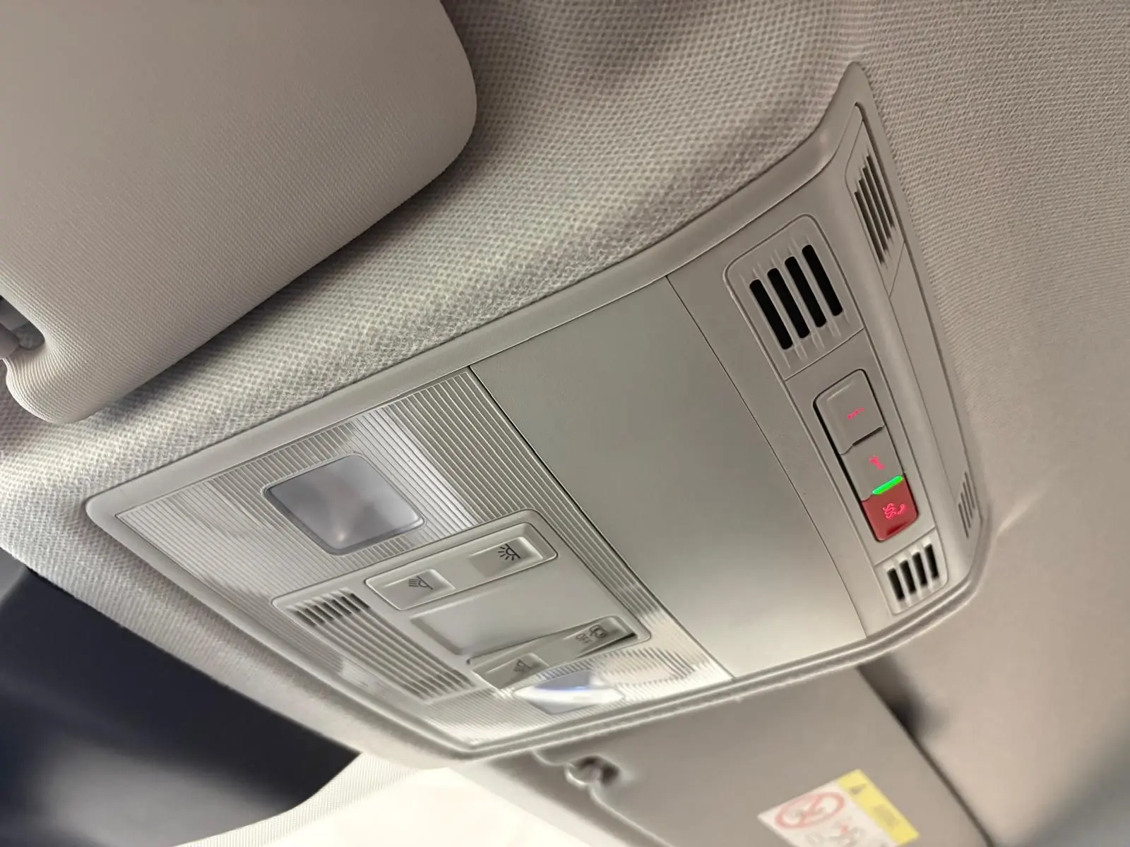 Plafonnier intérieur gris clair du SEAT Arona 2025 avec commandes d’éclairage et ventilation, vue en léger contre-plongée.