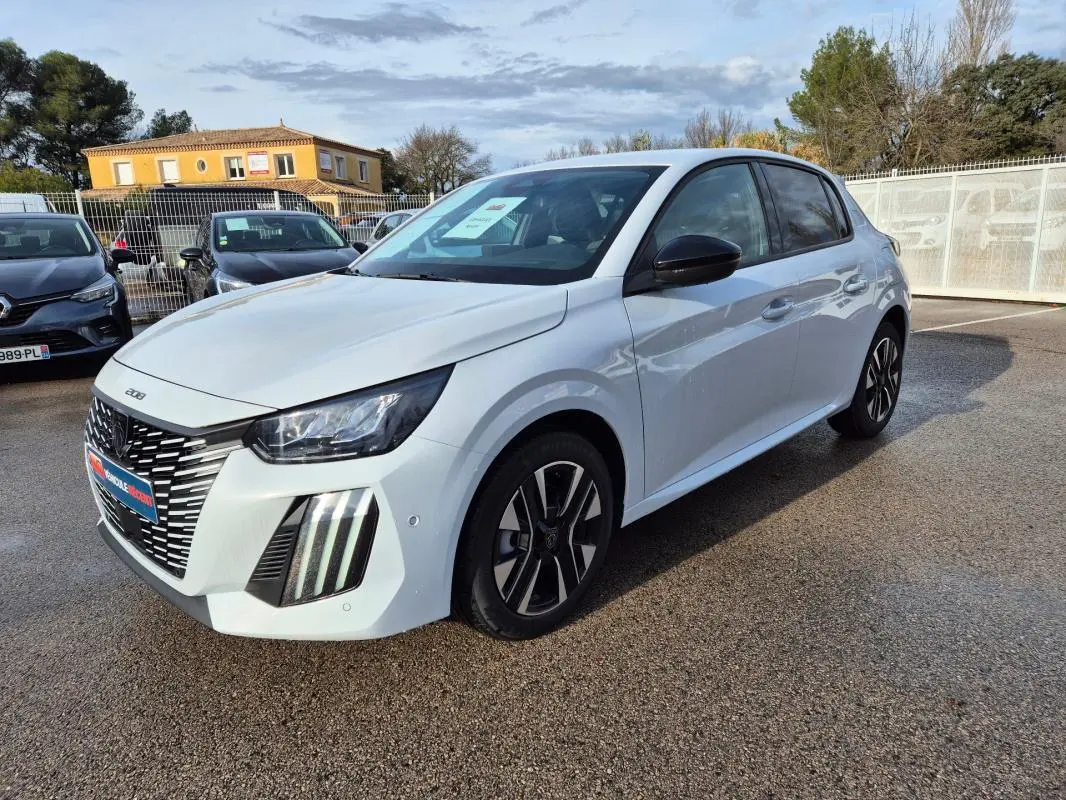 Peugeot 208 Hybrid blanc vue 3/4 avant droit, avec jantes alliage 16 pouces et feux diurnes distinctifs.