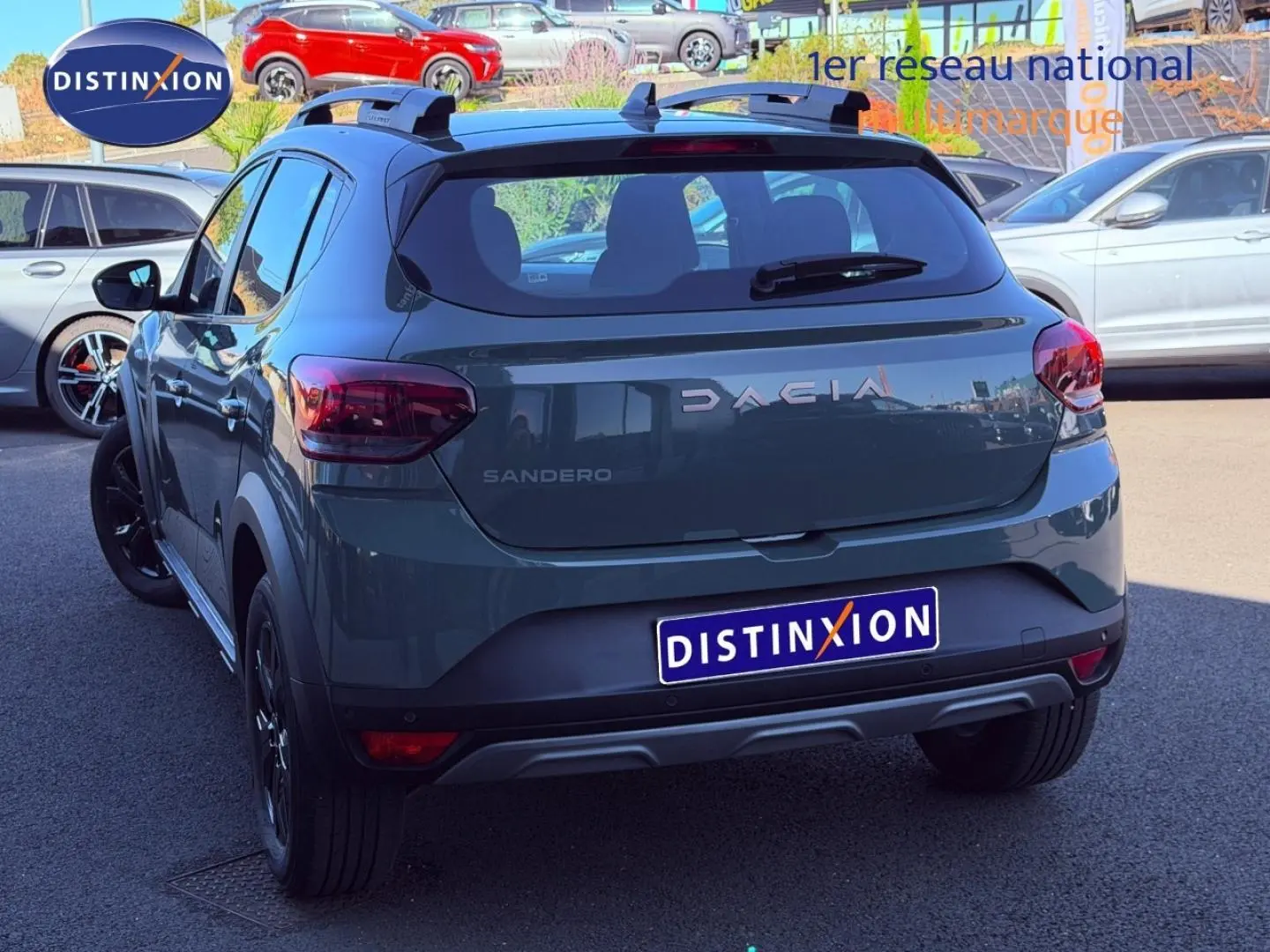 Vue 3/4 arrière droite d'une Dacia Sandero Stepway 2025 en kaki lichen avec barres de toit et jantes noires.