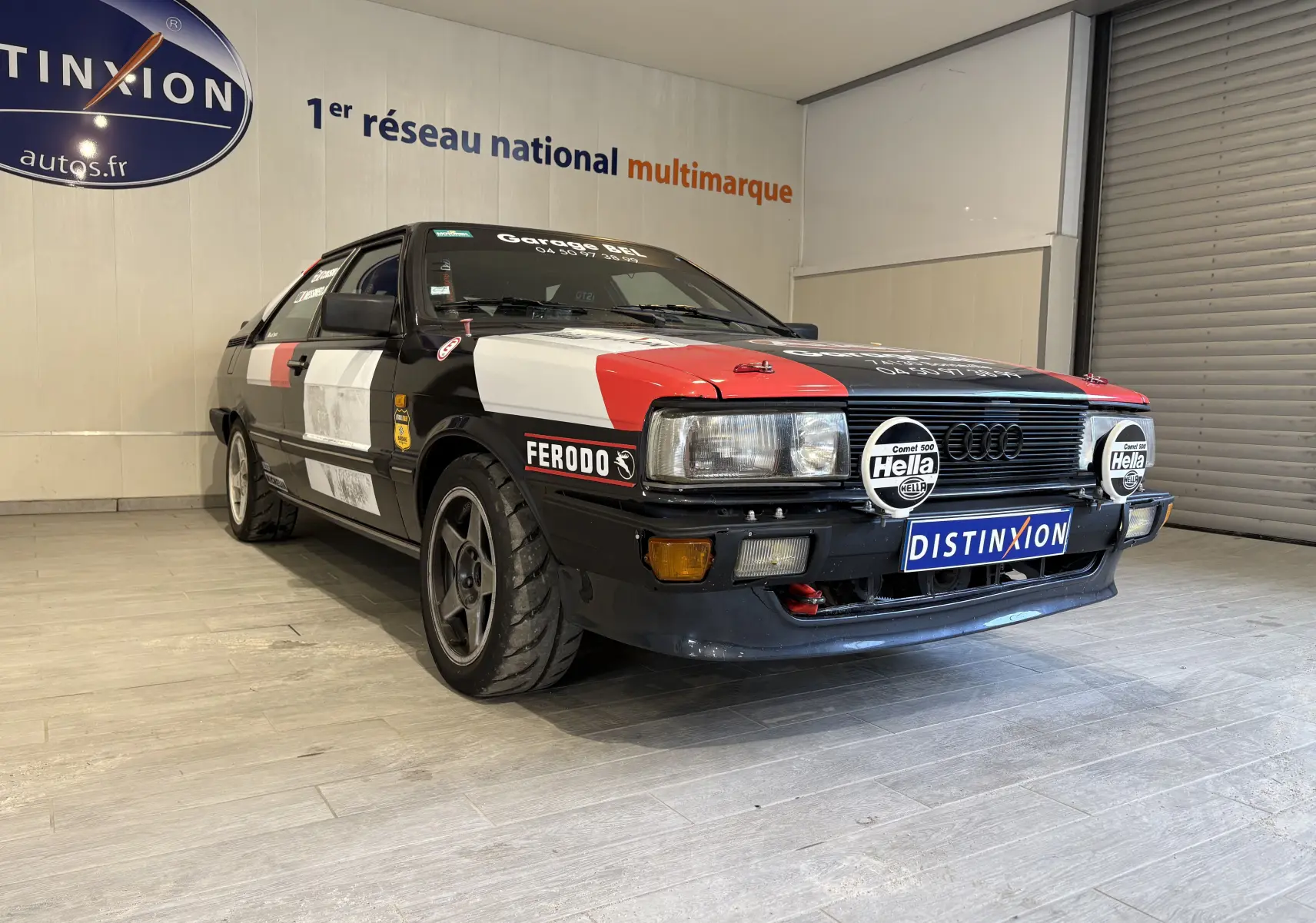 Audi Coupé GT noir vue 3/4 avant droit avec stickers rallye rouges et blancs et phares additionnels Hella.