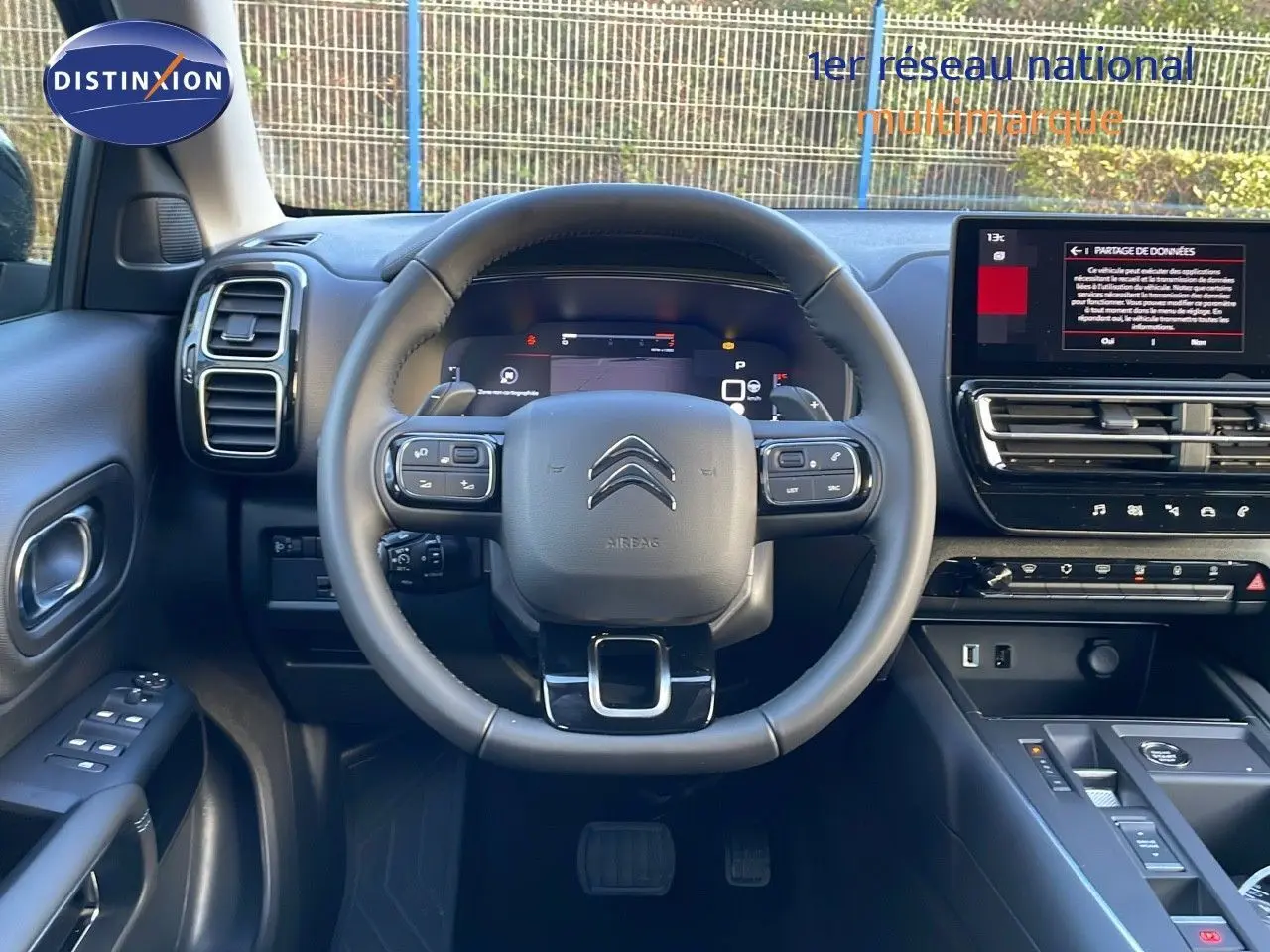Vue intérieure centrée sur le volant et tableau de bord du Citroën C5 Aircross 2025 en cuir noir avec écran tactile.