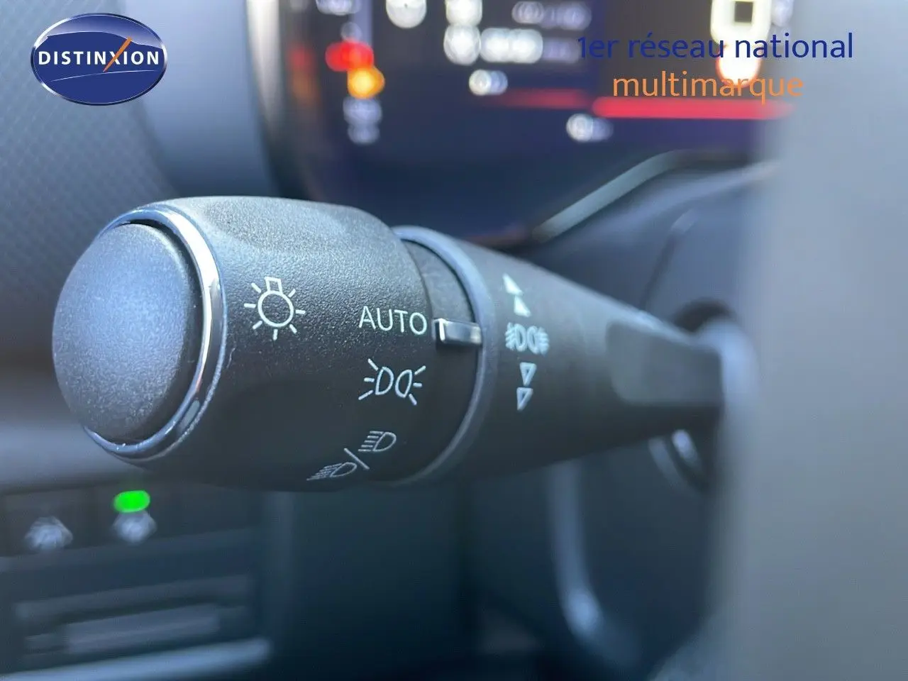 Gros plan sur la commande des feux du Citroën C5 Aircross noir Perla Metal, intérieur avec tableau de bord flou.