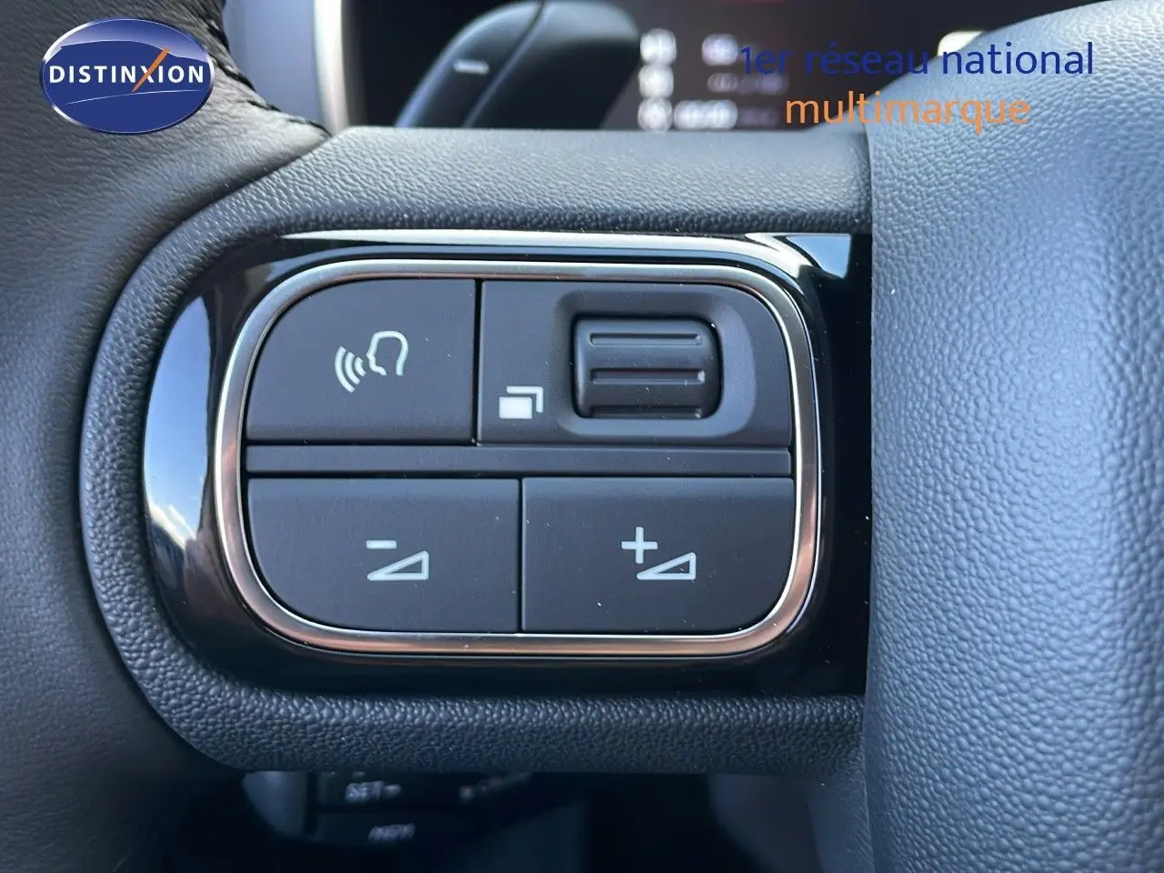Gros plan sur les commandes au volant du Citroën C5 Aircross 2025, finition cuir noir, boutons de réglage du volume et appels.