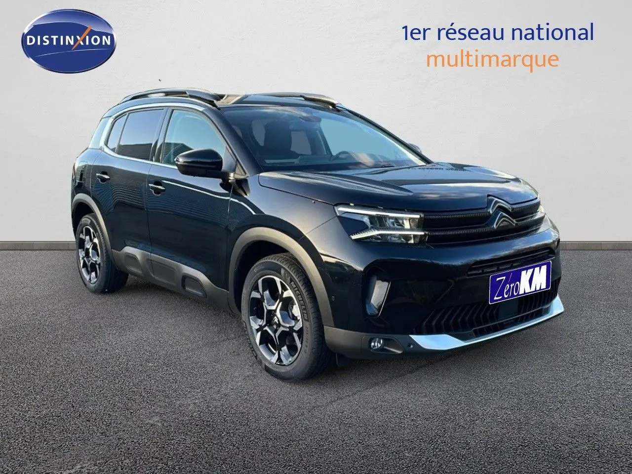 Citroën C5 Aircross noir perla metal en 3/4 avant droit, avec jantes bi-ton et barres de toit visibles.