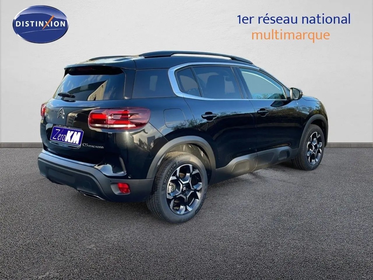 Vue 3/4 arrière droite du Citroën C5 Aircross noir perla metal avec jantes bicolores et toit panoramique.