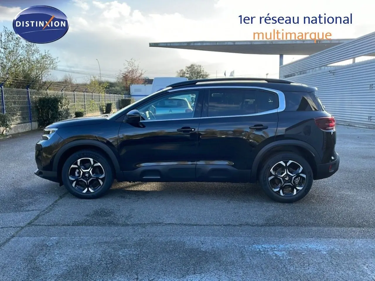 Vue de profil côté gauche d'un Citroën C5 Aircross 2025 noir Perla Metal avec jantes bi-ton et barres de toit.