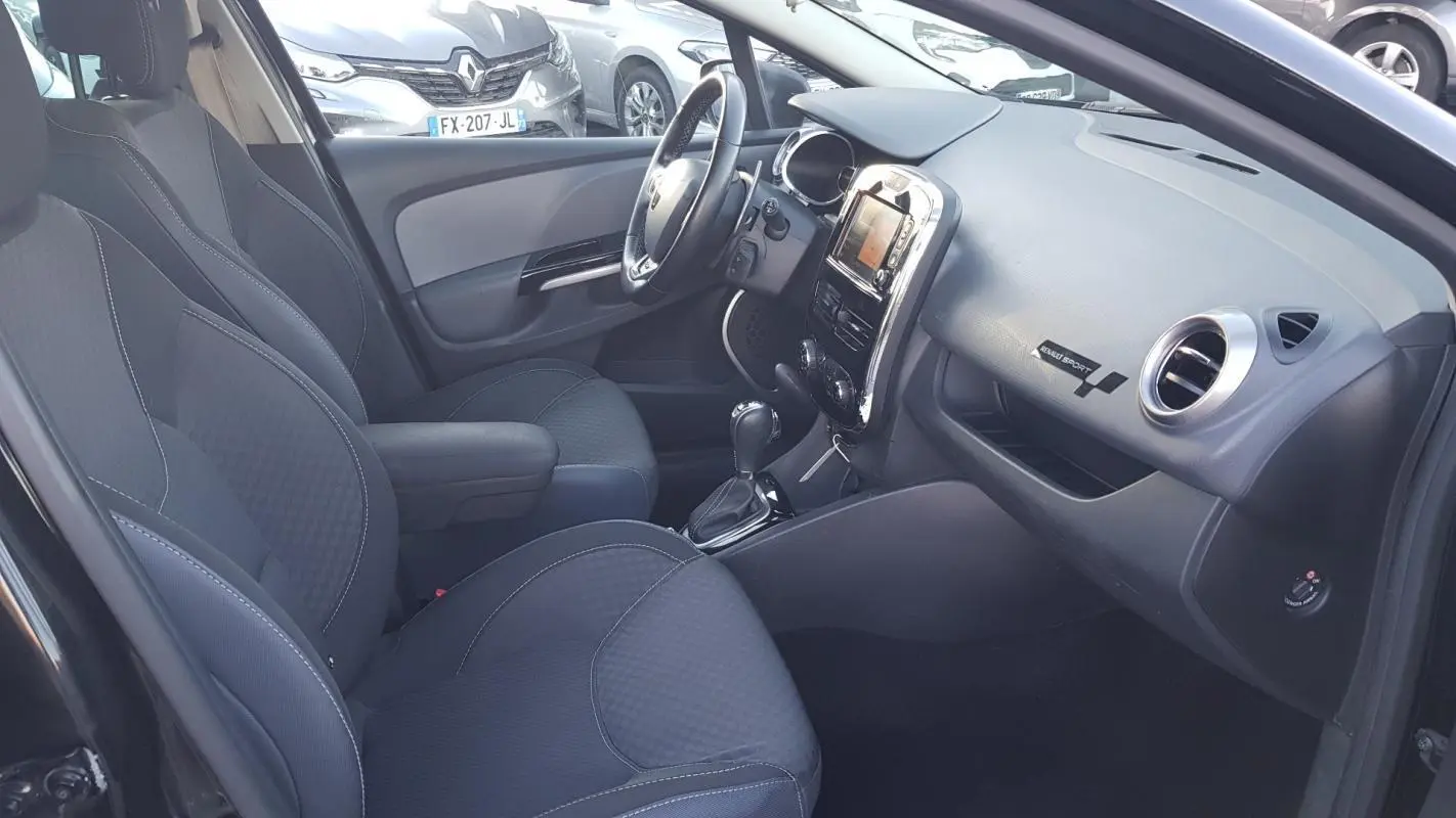 Intérieur avant droit de la Renault Clio IV Estate TCe 120 GT EDC 2015 avec sièges noirs et tableau de bord sport.