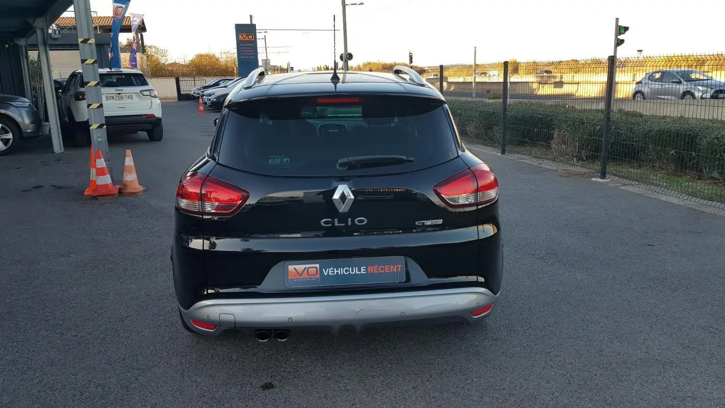 Vue arrière d'une Renault Clio IV Estate TCe 120 GT noire avec feux rouges et vitres surteintées.