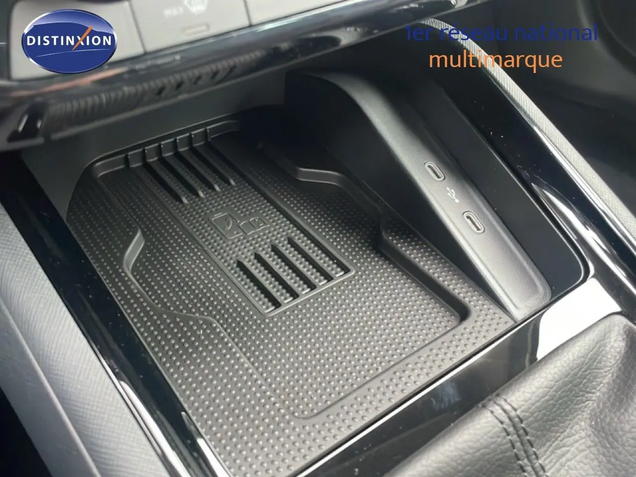 Gros plan sur la console centrale noire du Skoda Kamiq 2025 avec zone de recharge sans fil et ports USB visibles.