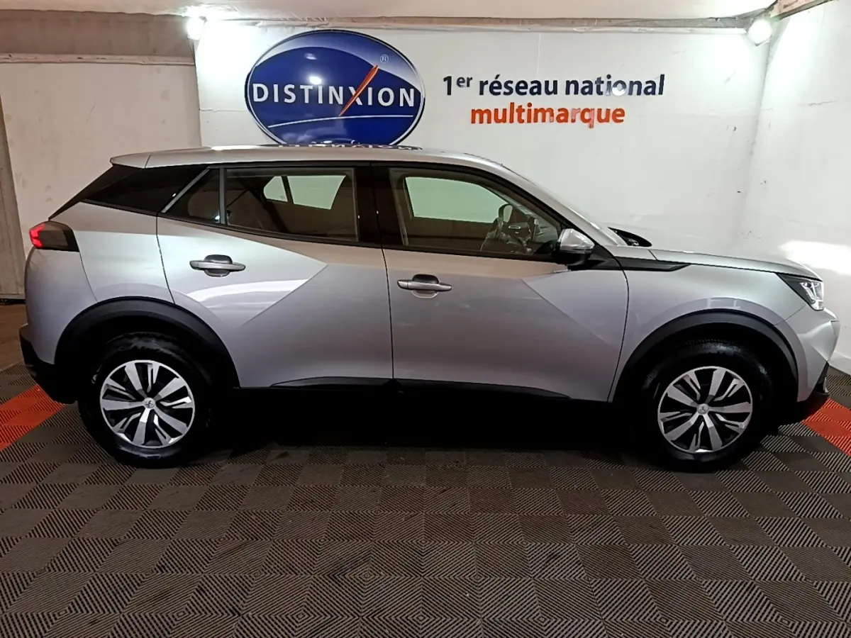 Vue de profil côté gauche d’un Peugeot 2008 gris clair, soulignant ses lignes modernes et ses jantes alliage.