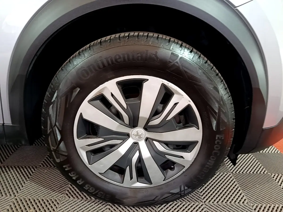Gros plan sur la roue avant droite d’un Peugeot 2008 gris clair, avec jante alliage et pneu Continental.