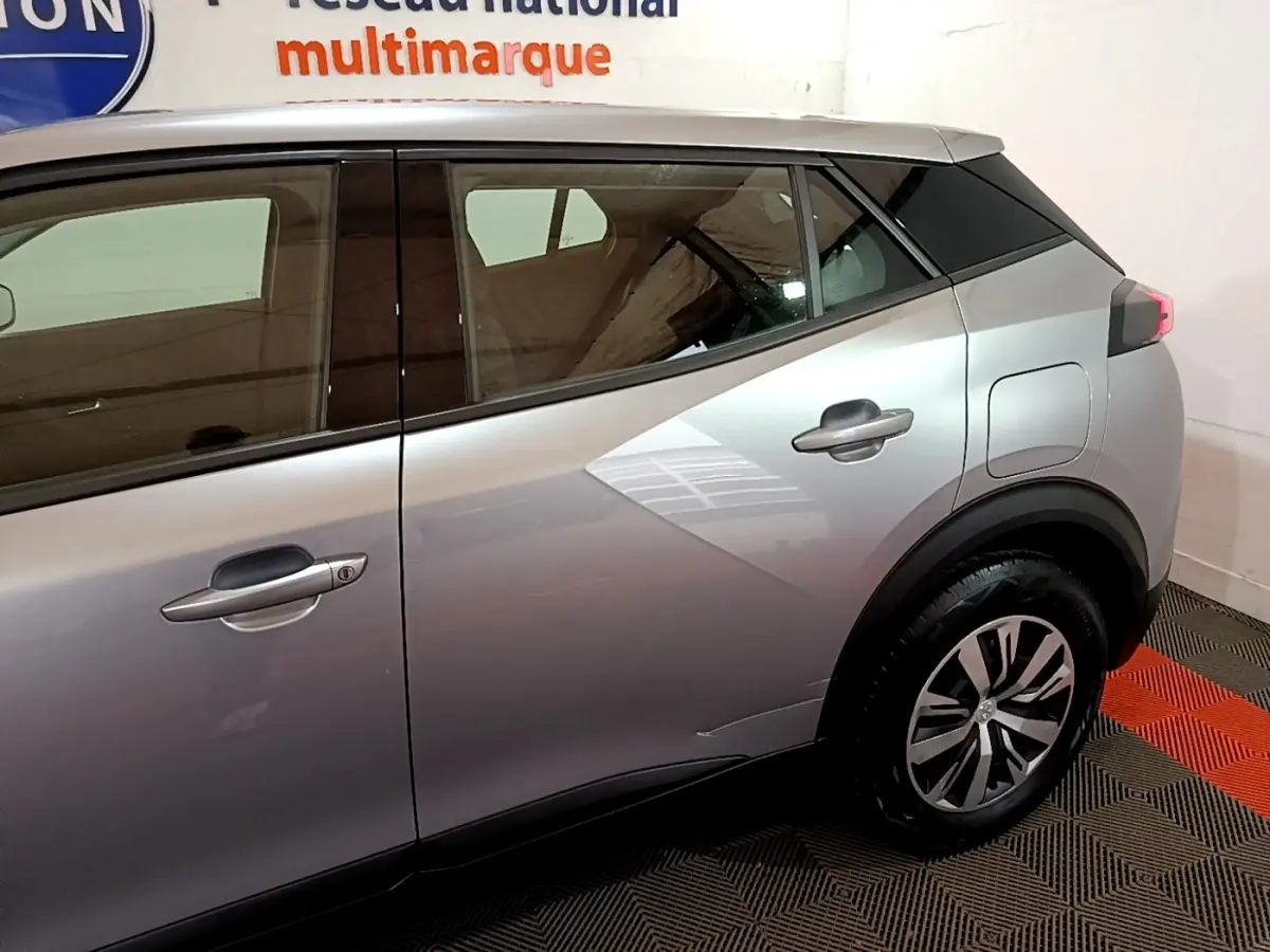 Vue côté droit arrière du Peugeot 2008 gris clair, mettant en valeur les lignes anguleuses et les jantes modernes.